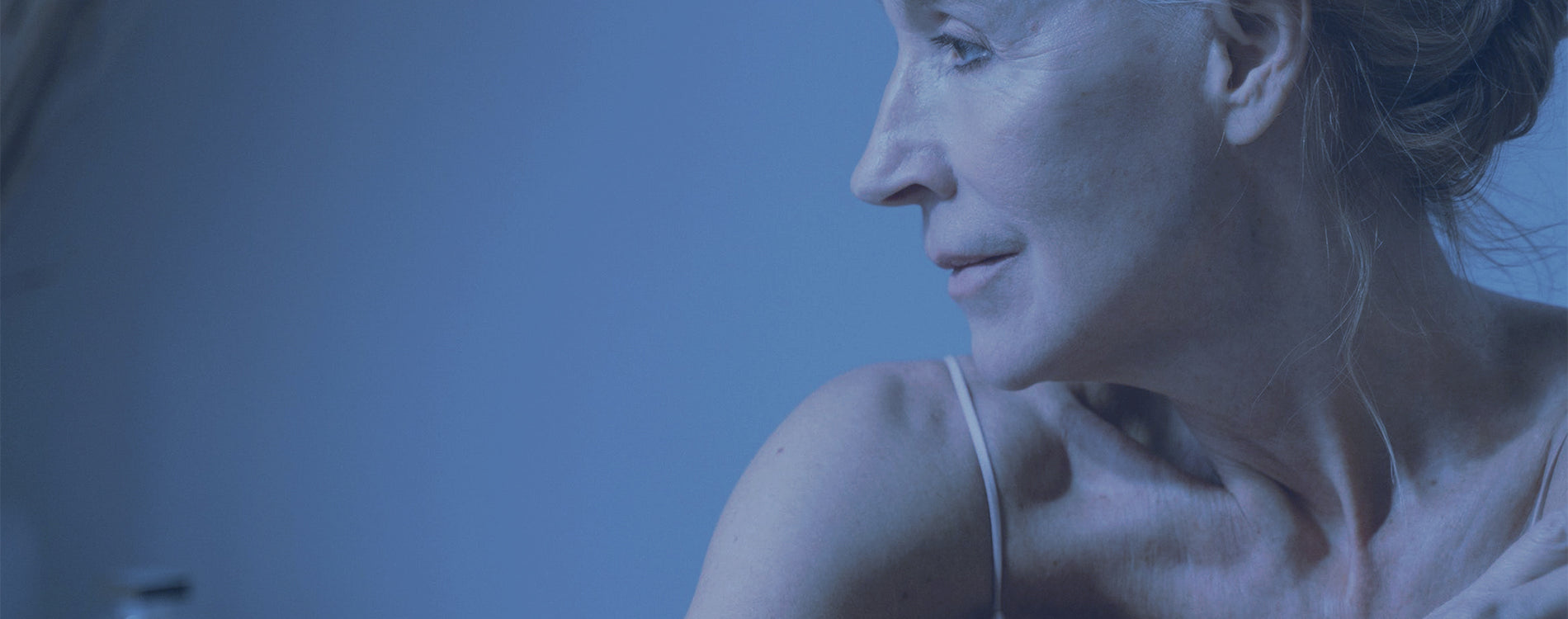 Somewhat older woman sitting with her arms crossing her chest