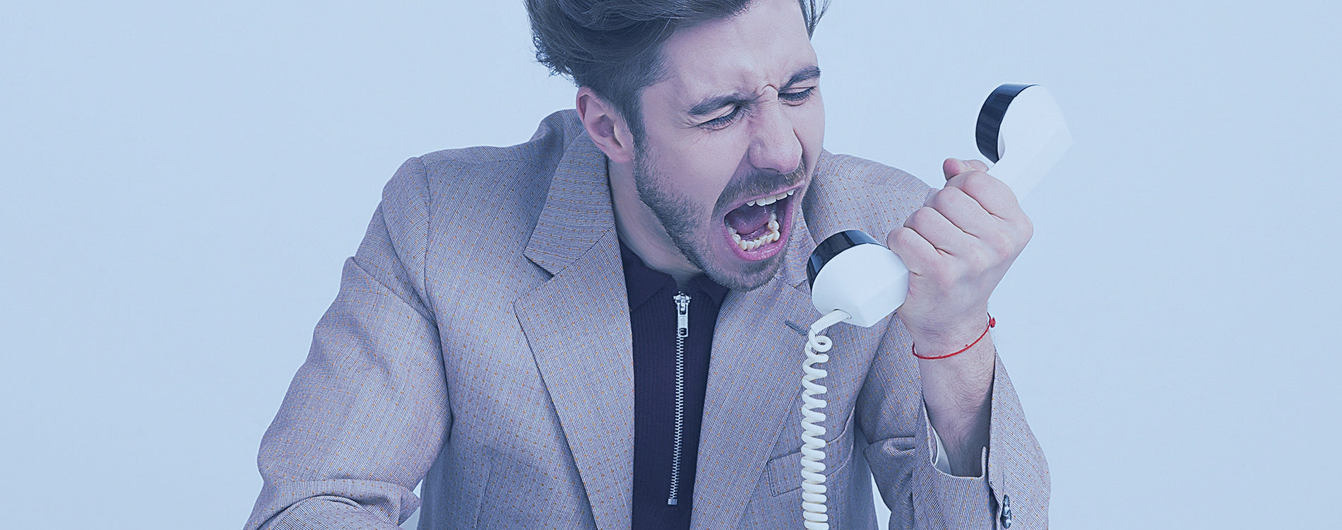 Man yelling into an old school telephone