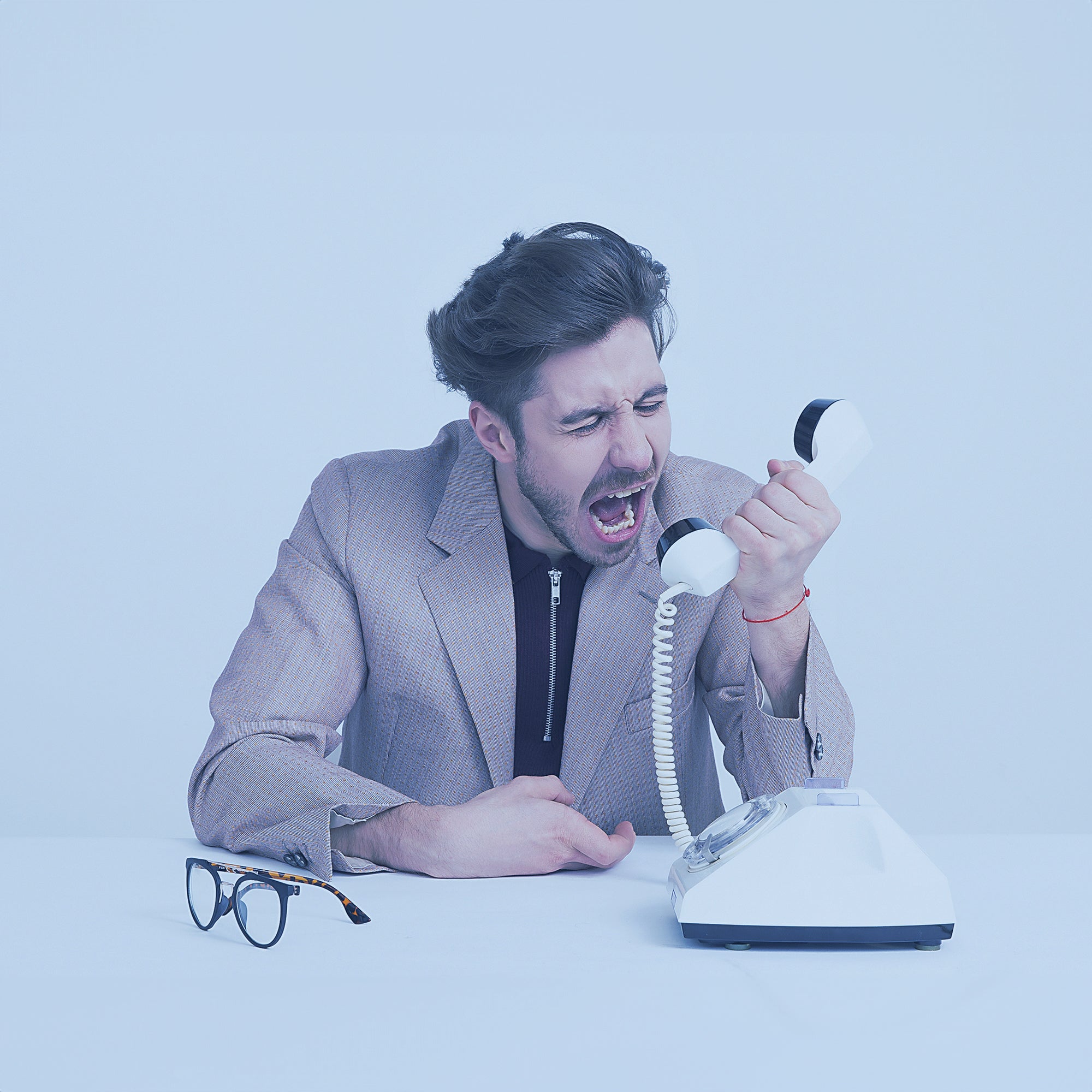 Man yelling into an old school telephone