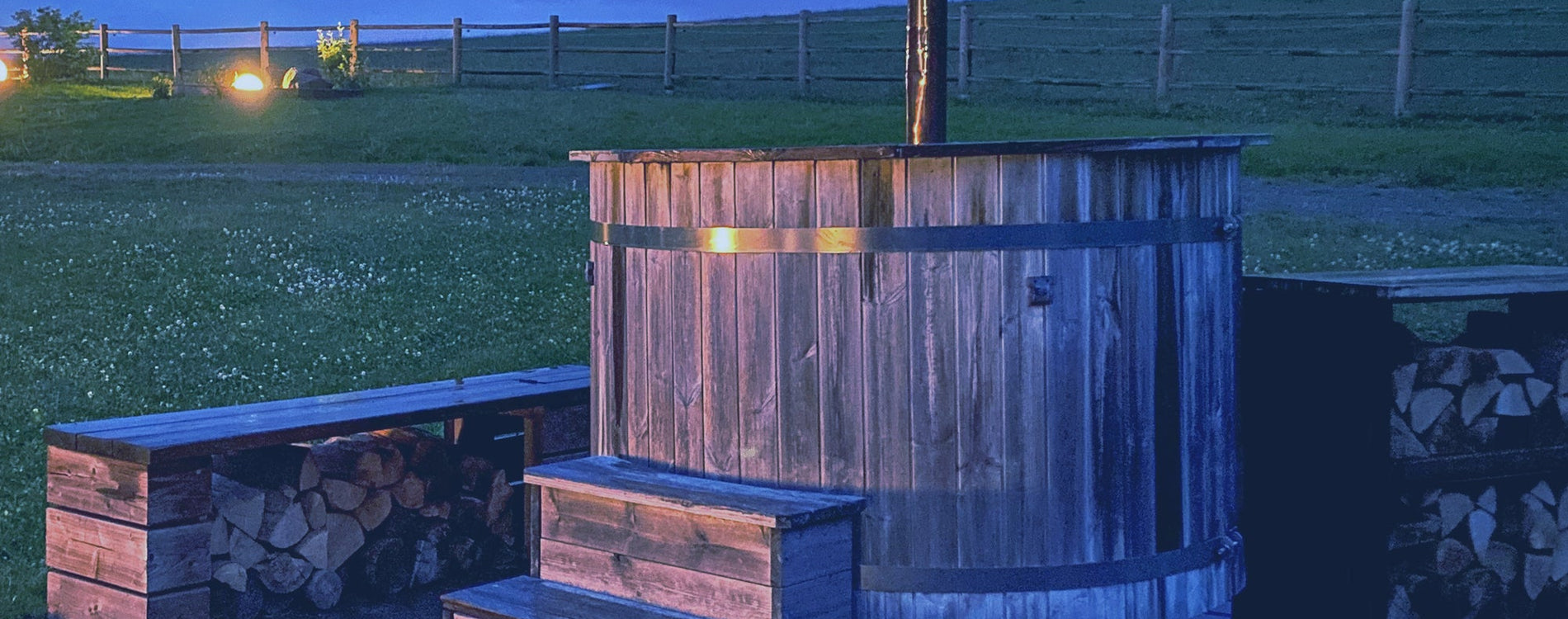 A wooden hot tob outside on a farm