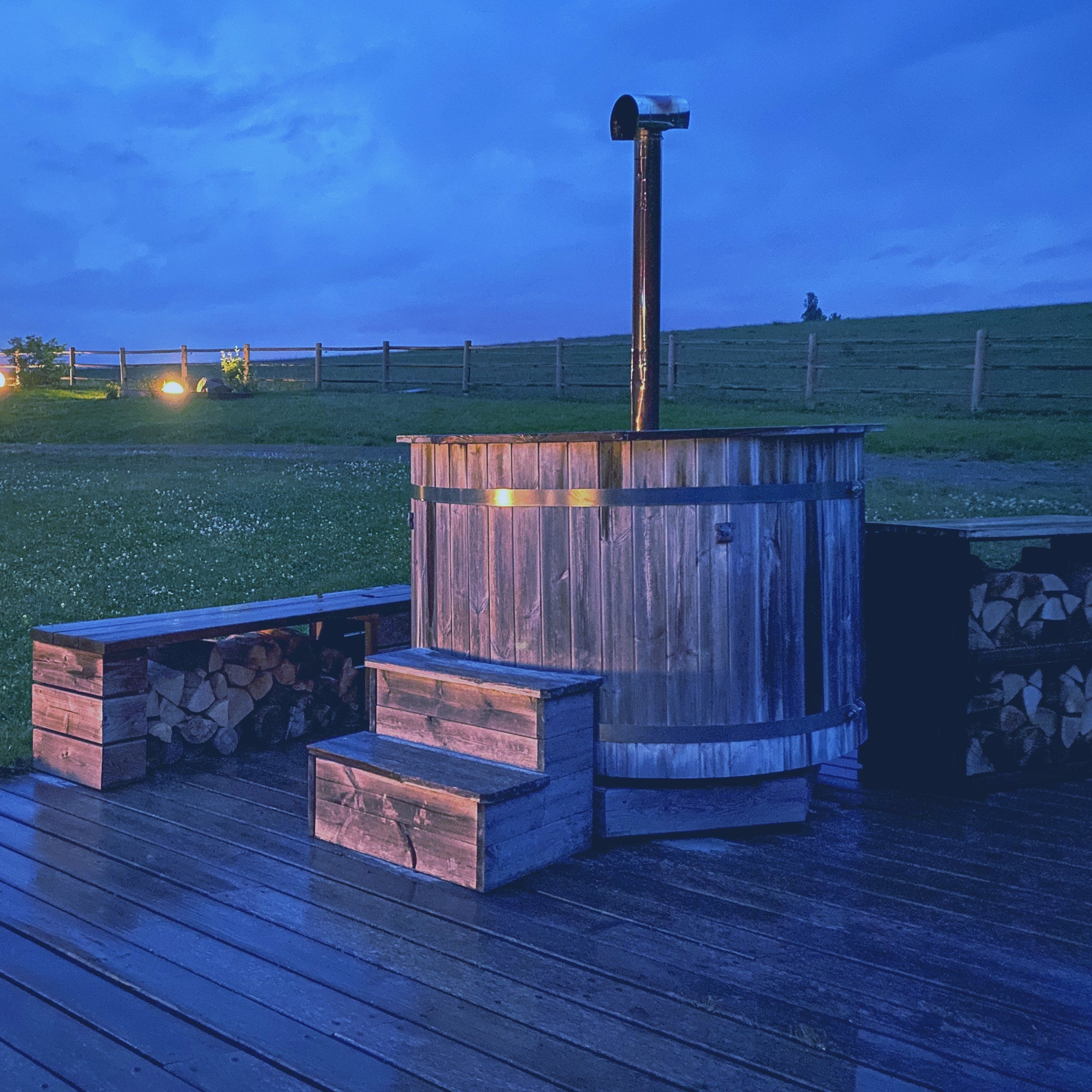A wooden hot tob outside on a farm