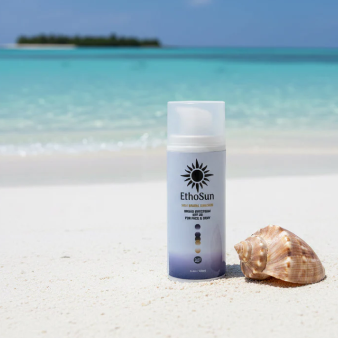 EthoSun sunscreen SPF 40+ bottle, on a sandy beach with shell and in an island background