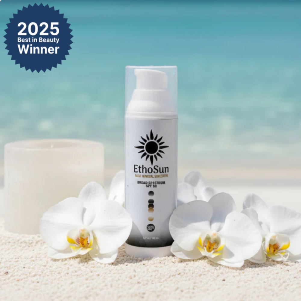 2025 Best in Beauty Winner EthoSun Daily Mineral Sunscreen Broad Spectrum SPF 50 in Bottle with candle and white petals background