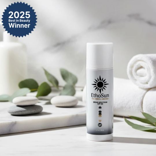 EthoSun Daily Meniral sunscreen broad spectrum SPF 50 bottle on a marble surface with spa elements and 2025 Best in Beauty Winner badge.