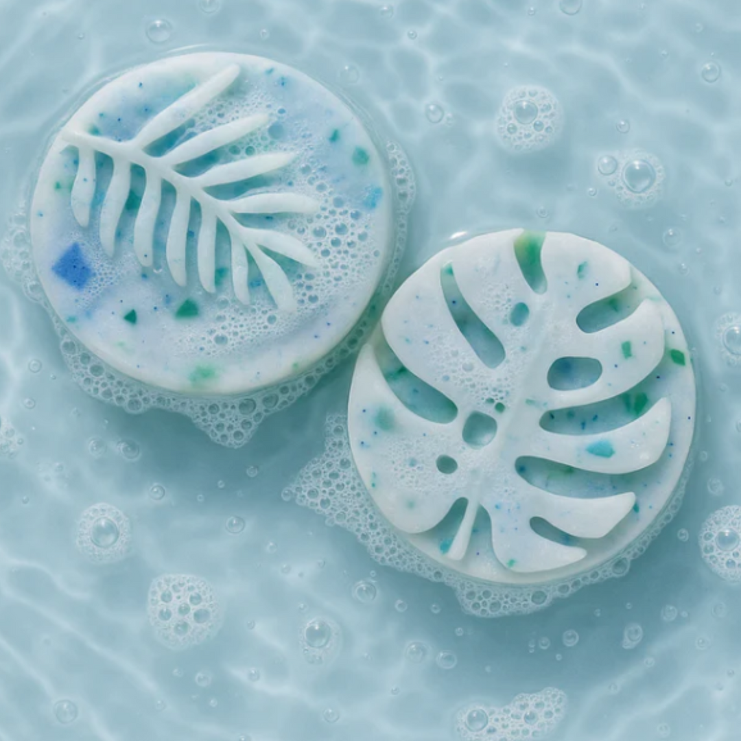 Two leaf-shaped sponges with a floral pattern on a blue liquid background