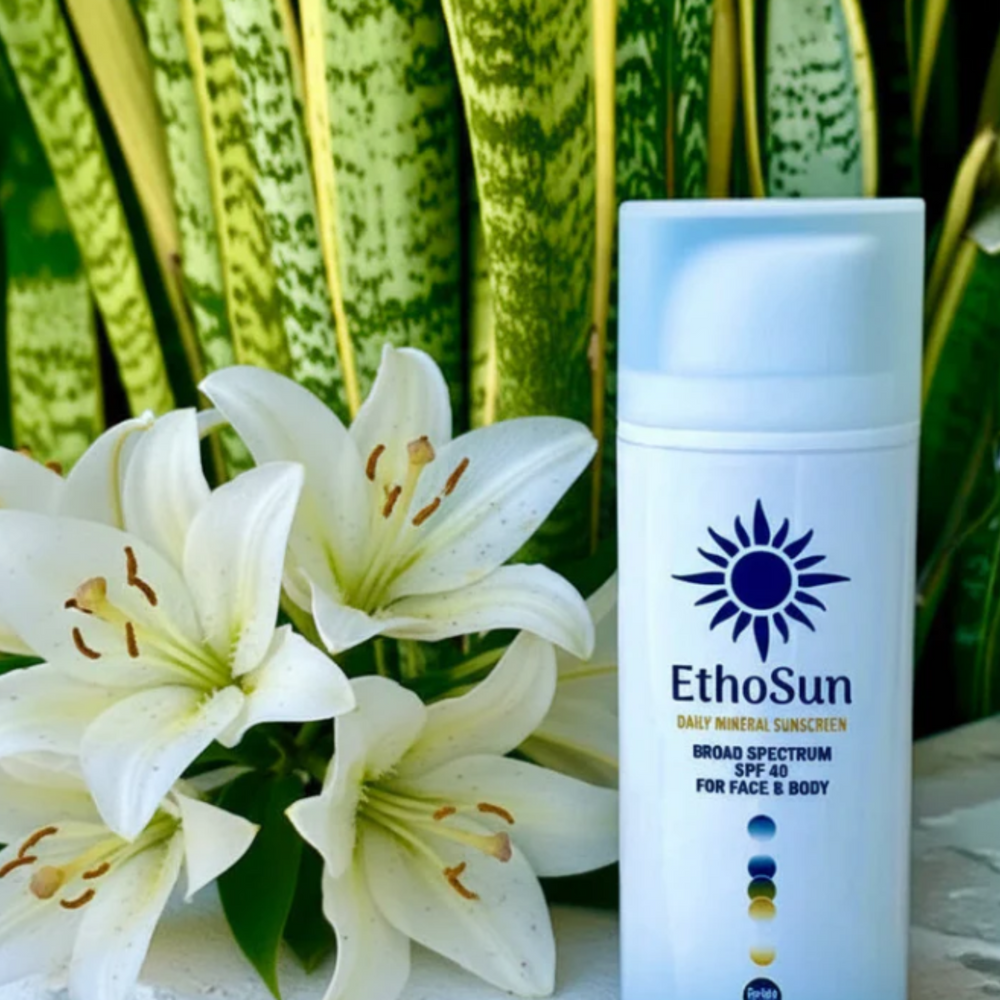 EthoSun sunscreen bottle with white lilies and green plants in the background