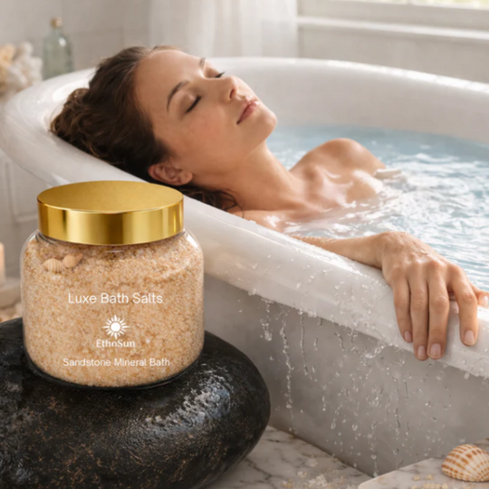 Woman relaxing in a bathtub with a jar of Luxe Bath Salts on a stone.