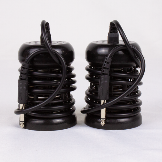 Two black electronic connectors with coiled cables on a white background