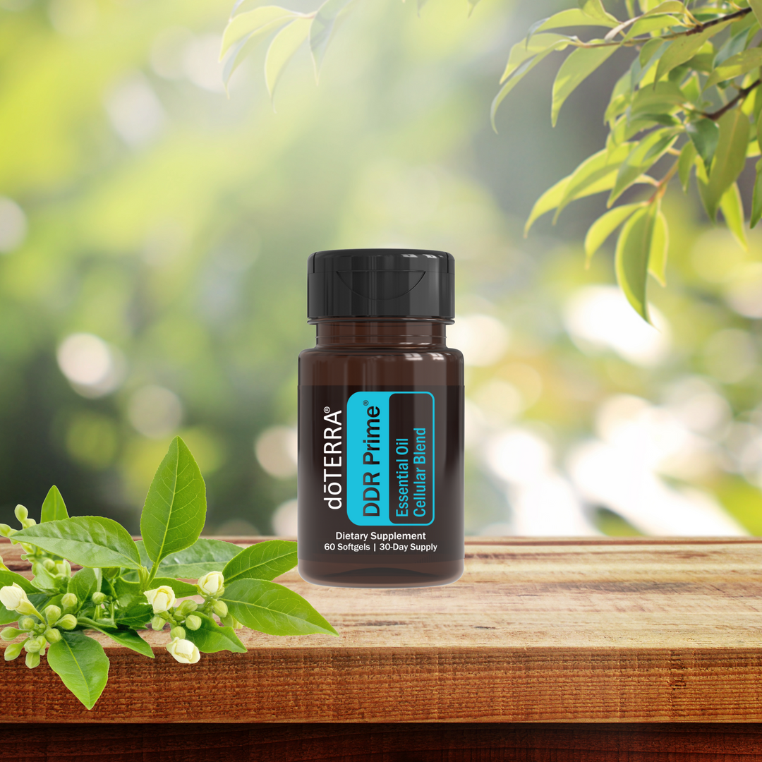 DoTERRA DDR Prime essential oil bottle on a wooden surface with green leaves in the background