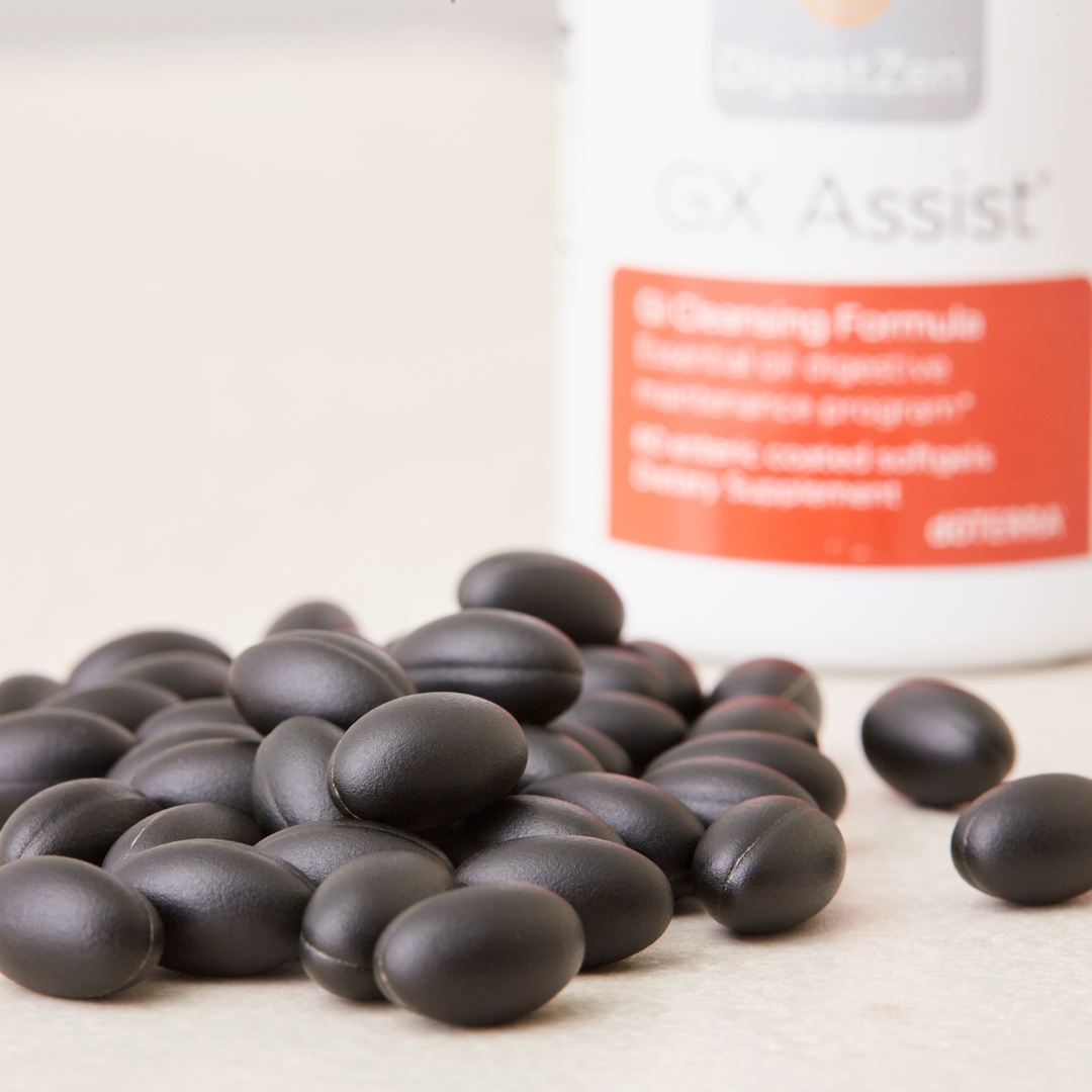 Black capsules with a supplement bottle labeled 'Assist' on a light background