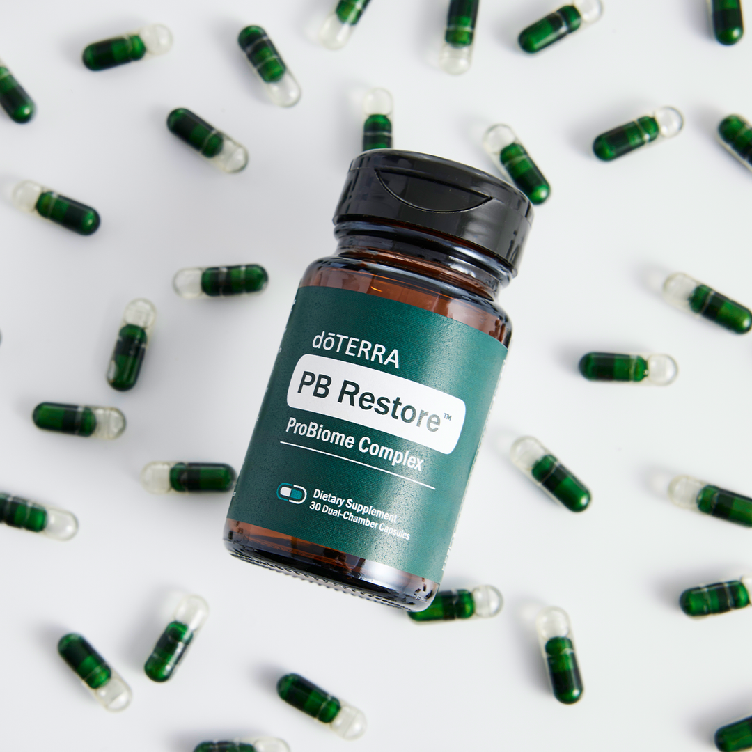 doTERRA PB Restore ProBiome Complex bottle surrounded by green capsules on a white background