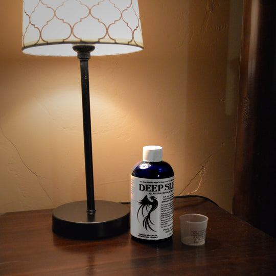 Deep Sleep Natural Sleep Aid next to bedside lamp